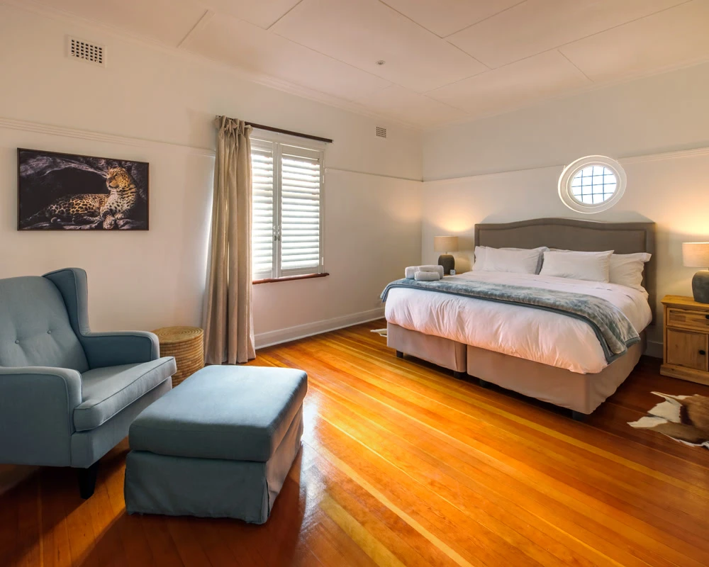 Slaapkamer in afkickkliniek Zuid-Afrika met luxe bed en rustige uitstraling.