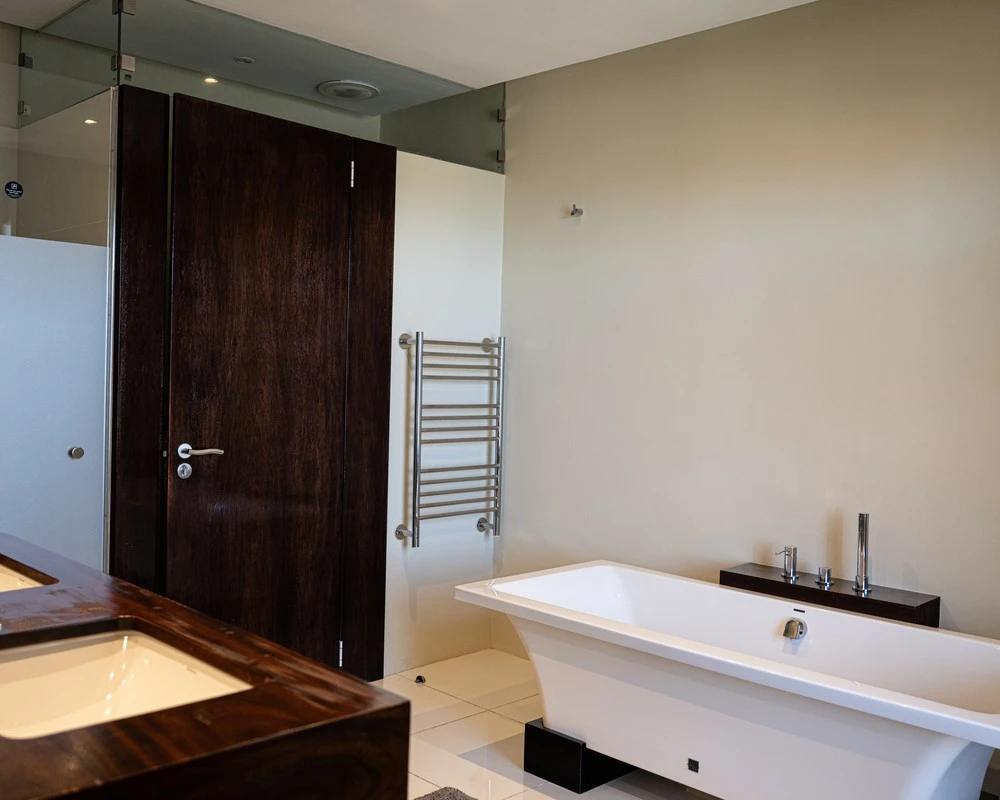 Bathroom with freestanding bath and wooden vanity unit in a rehabilitation centre in South Africa.