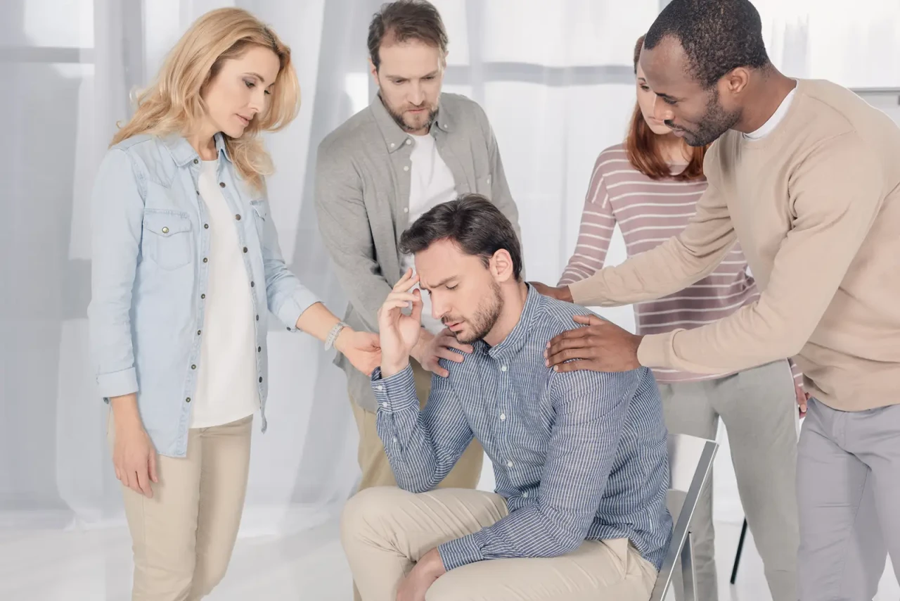 man-being-comforted-by-four-people man-being-comforted-by-four-people