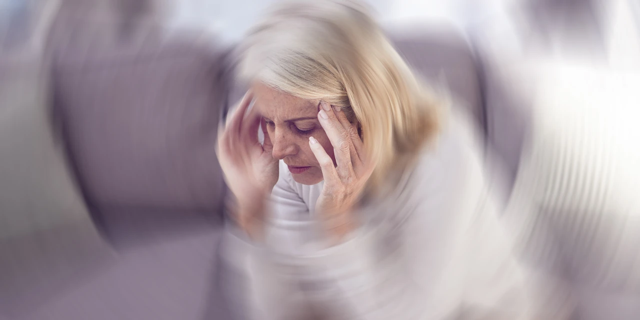 A woman holds her head while experiencing dizziness, confusion and physical discomfort often associated with panic attacks and anxiety.