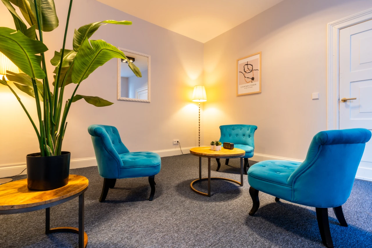 Behandelkamer voor gesprekken en behandeling bij verslaving met drie blauwe stoelen.