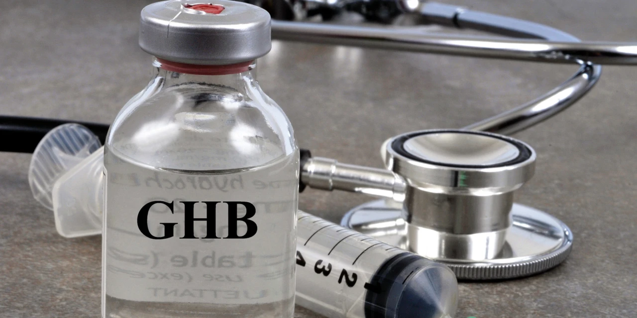 A bottle labelled GHB stands next to a syringe and stethoscope, illustrating the serious health risks and medical consequences linked to GHB addiction.