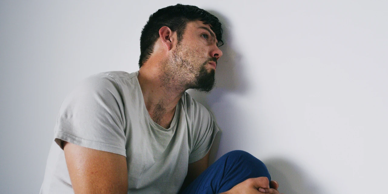 man-leaning-against-wall-during-detox