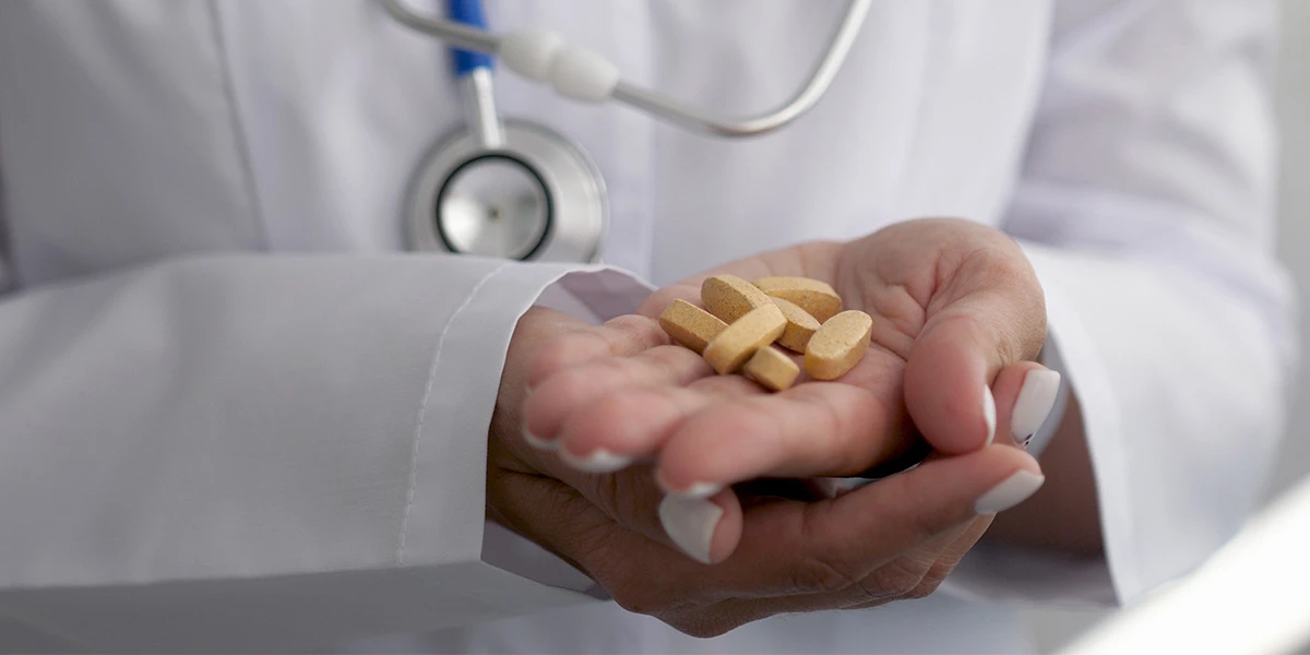Doctor holding a handful of tablets, illustrating Adderall addiction.