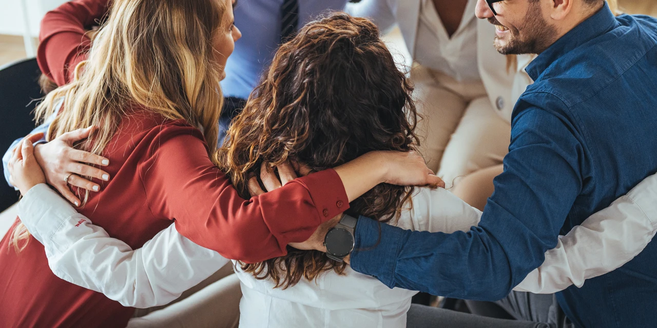 On the CMH about us page, people in recovery support each other during a group therapy session focused on connection and healing.