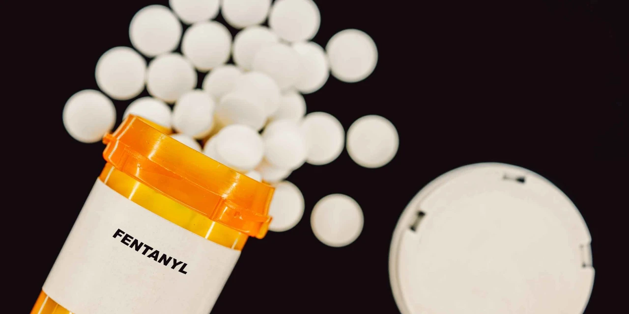 Fentanyl tablets spill from a prescription container, highlighting the risks and dependency connected to fentanyl addiction.
