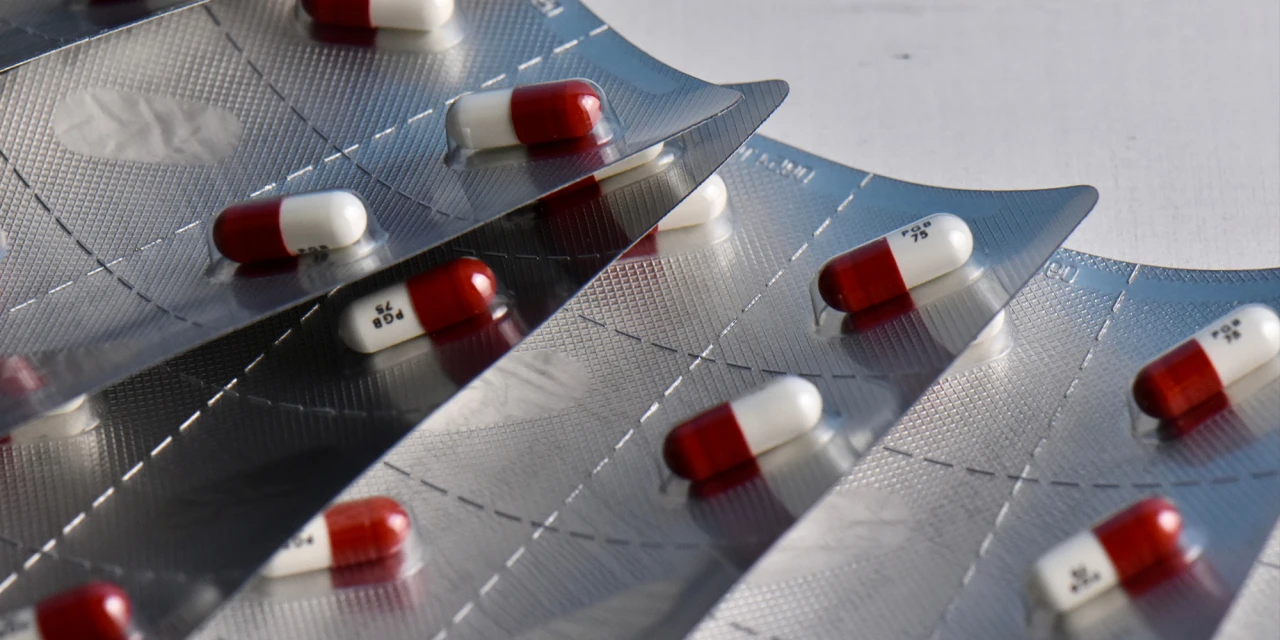 Several red and white pregabalin capsules remain sealed in blister packs, representing prescribed medication associated with pregabalin addiction.