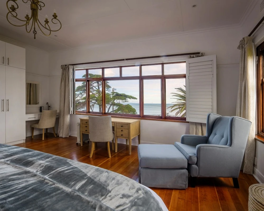 Bedroom with a desk and sea view at a rehabilitation centre in South Africa.