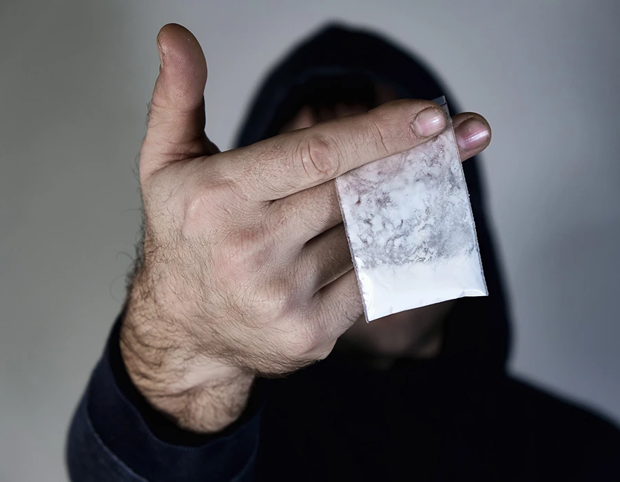 Person holding a bag of cocaine, illustrating the struggle with cocaine addiction.