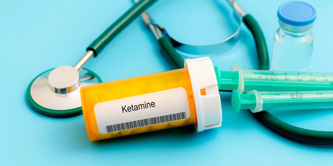 A container labelled ketamine lies beside syringes and medical equipment, highlighting the dangers and health risks associated with Ketamine addiction.