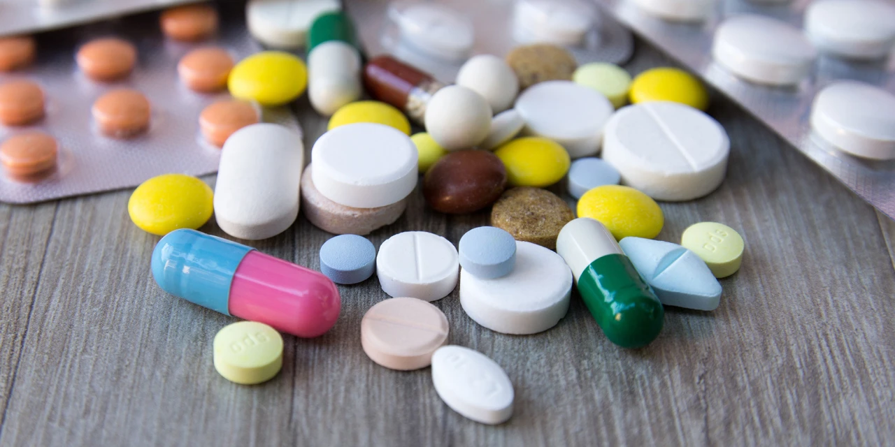Various prescription drugs and tablets scattered across a table, showing different forms of medication linked to prescription drug misuse and addiction.